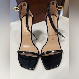 Stuart Weitzman Nudistcurve 100 Black Patent Ankle Strap Heels with Gold Buckle